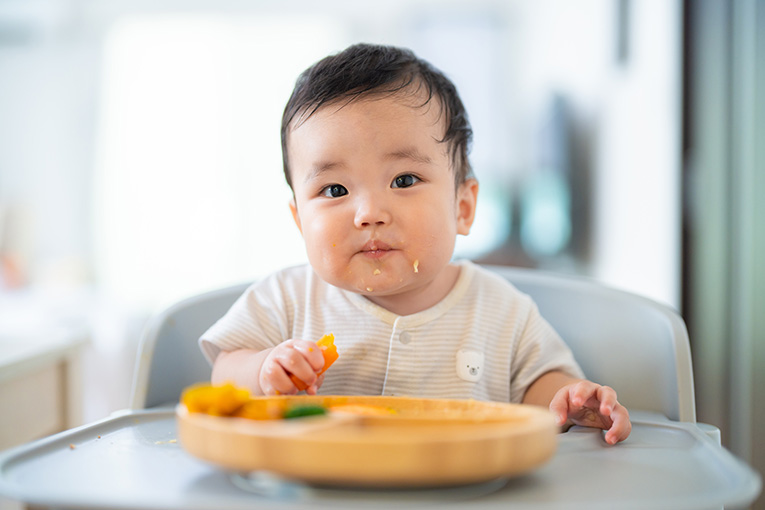 手づかみで離乳食を食べる赤ちゃん