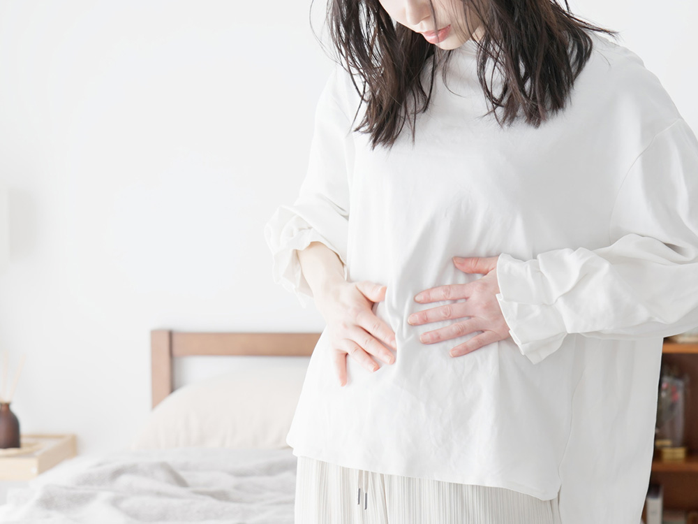 お腹に違和感を感じている妊婦