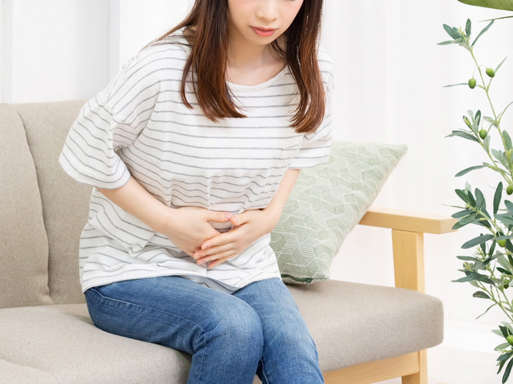 腹痛でお腹を押さえている妊婦