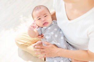 母親に抱かれながら、泣いている赤ちゃん